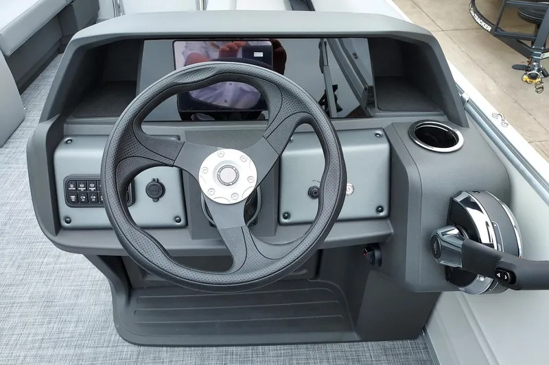 Slide: The Image of 2026 Sun Tracker Party Barge 18 DLX steering console with modern controls and cup holder. - 2