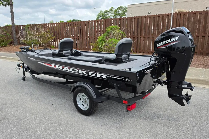 Slide: The Image of 2026 Tracker Panfish 17 boat with Mercury engine on trailer, parked outdoors. - 8