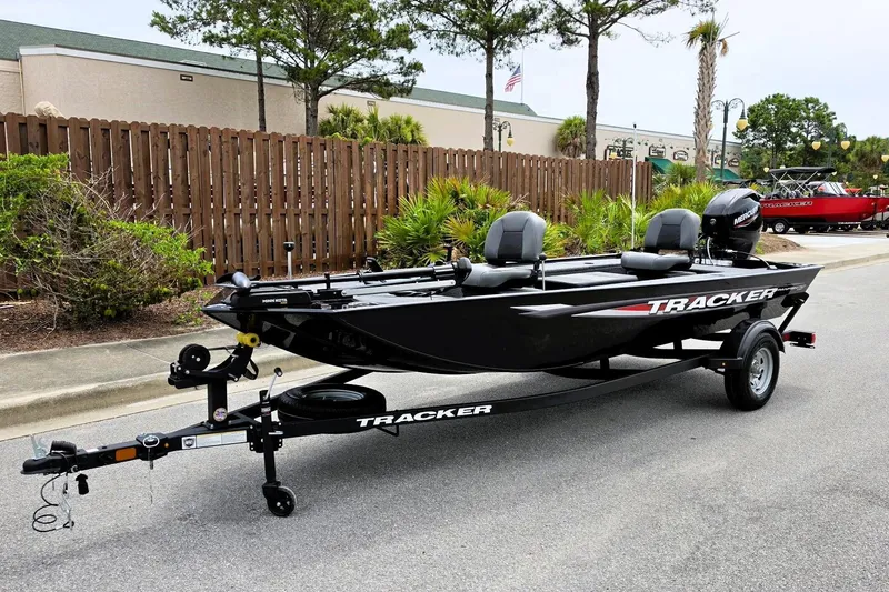 Slide: The Image of 2026 Tracker Panfish 17 boat on trailer, parked outdoors, featuring sleek black design. - 7