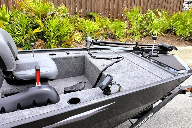 Slide: The Image of 2026 Tracker Panfish 17 boat interior with seating, fishing equipment, and lush greenery background. - 11