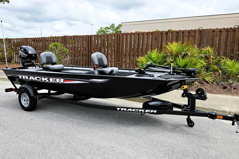 Slide: The Image of 2026 Tracker Panfish 17 boat on trailer, parked outdoors near wooden fence. - 3