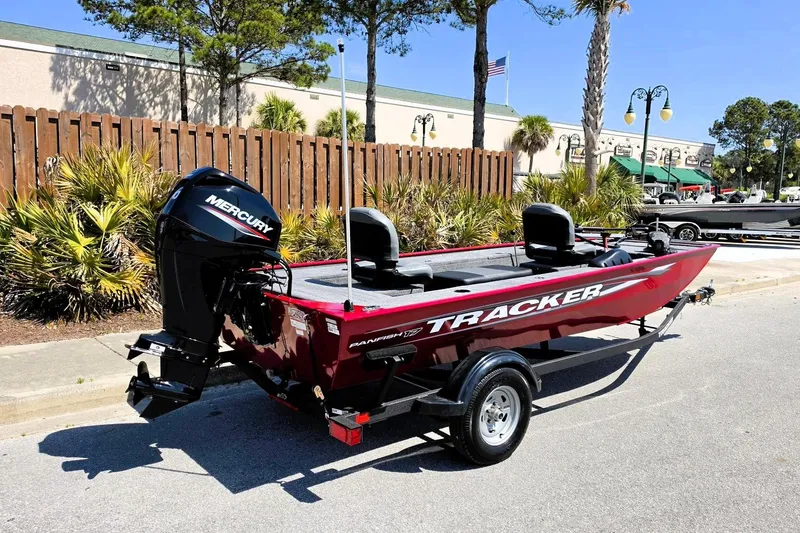 Slide: The Image of 2026 Tracker Panfish 17 boat with Mercury engine, parked outdoors on a sunny day. - 2