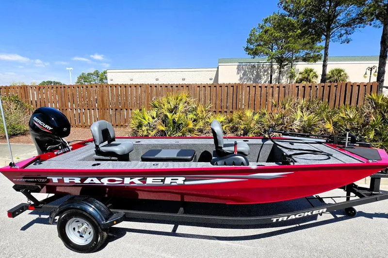 Slide: The Image of 2026 Tracker Panfish 17 boat, red exterior, parked outdoors on a trailer. - 4