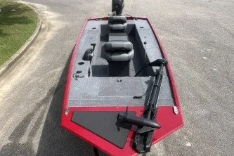 Slide: The Image of 2026 Tracker Panfish 17 boat with red exterior and seating, parked on pavement. - 3