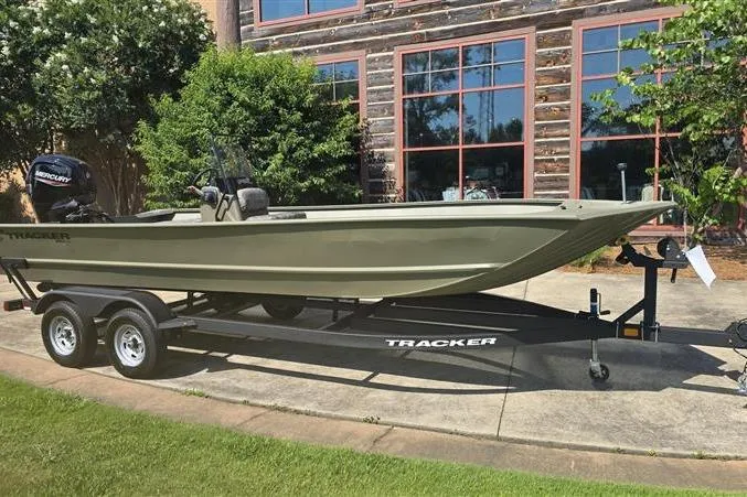 Slide: The Image of 2026 Tracker Grizzly 2072 CC boat on trailer, parked outdoors near a building. - 2