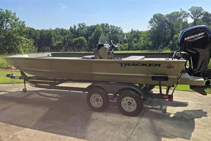 Slide: The Image of 2026 Tracker Grizzly 2072 CC boat on trailer with Mercury engine, parked outdoors. - 5