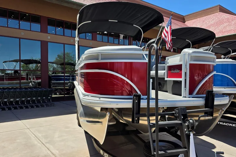 Slide: The Image of 2026 Sun Tracker SportFish 22 XP3 pontoon boat with red exterior, displayed outdoors. - 1