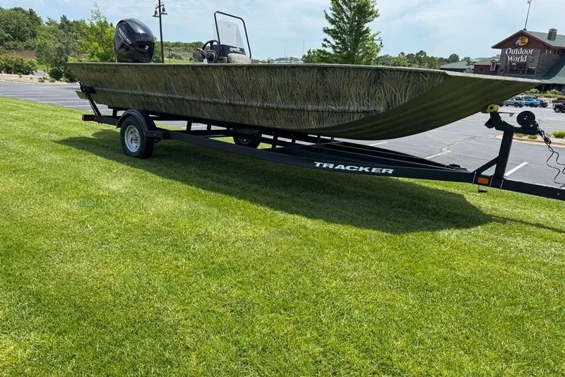 Slide: The Image of 2026 Tracker Grizzly 2072 CC boat on trailer, parked on grass near Outdoor World. - 2