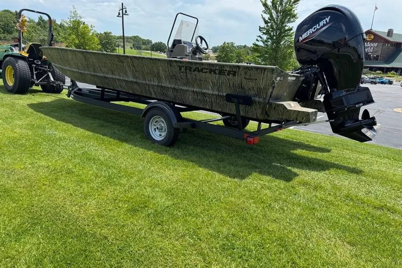 Slide: The Image of 2026 Tracker Grizzly 2072 CC boat on trailer, parked on grass, with Mercury outboard motor. - 4