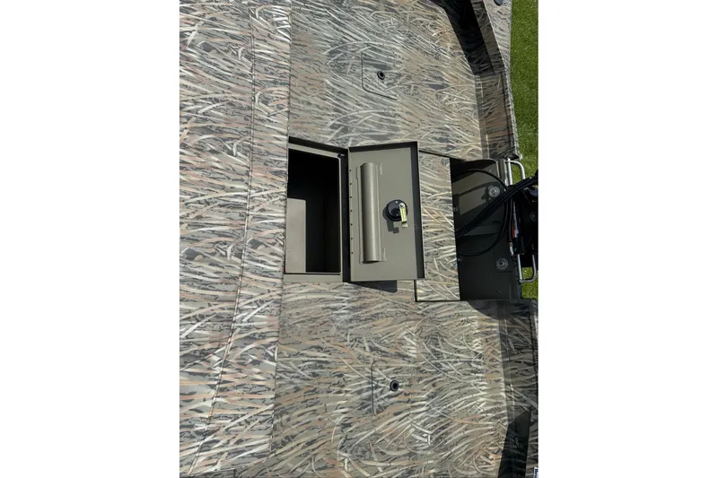 Slide: The Image of Camouflage-patterned deck of 2026 Tracker Grizzly 2072 CC with open storage compartment. - 6