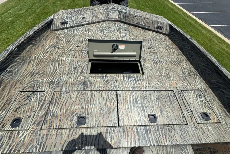 Slide: The Image of 2026 Tracker Grizzly 2072 CC boat deck with camo pattern and storage compartments. - 7