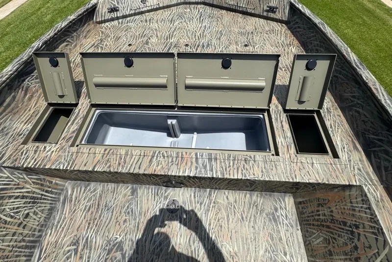 Slide: The Image of 2026 Tracker Grizzly 2072 CC boat with open storage compartments and camouflage design. - 8
