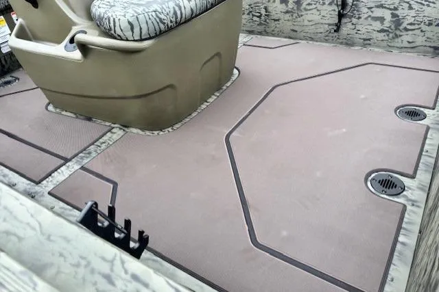 Slide: The Image of Interior view of 2026 Tracker Grizzly 1860 CC boat, featuring non-slip flooring and seating. - 10