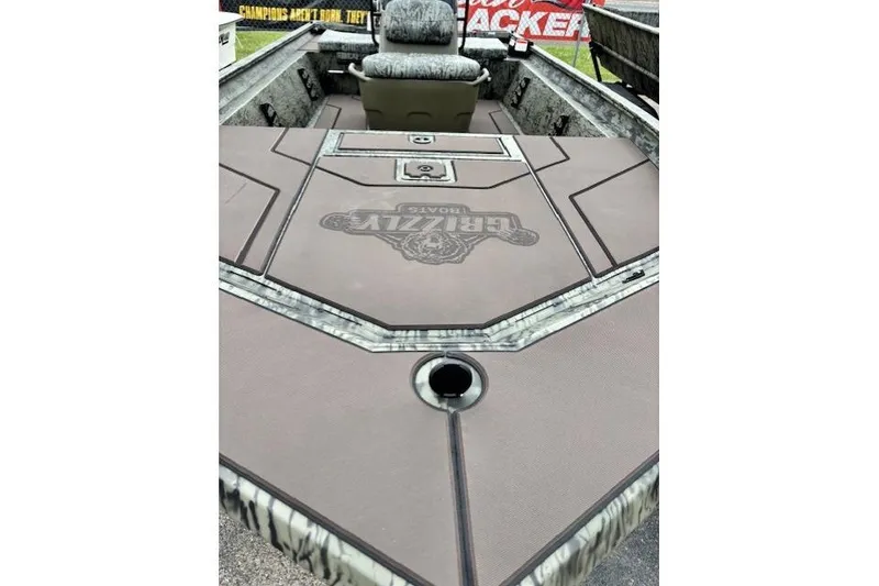 Slide: The Image of 2026 Tracker Grizzly 1860 CC boat interior with camo design and seating. - 9