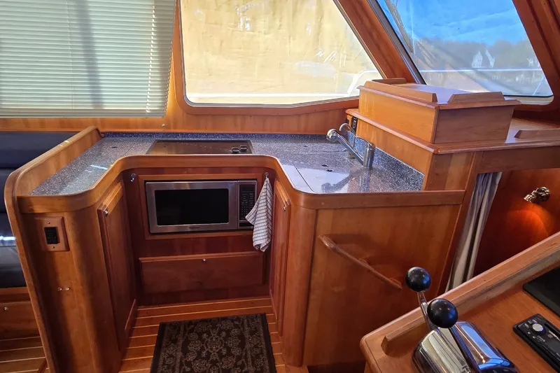 Slide: The Image of 2004 Sabre 36 yacht interior kitchen with wood cabinetry, microwave, and sink. - 35