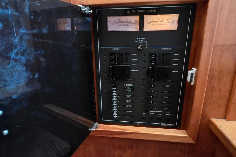 Slide: The Image of Electrical control panel inside a 2004 Sabre 36 boat, featuring various switches and meters. - 53