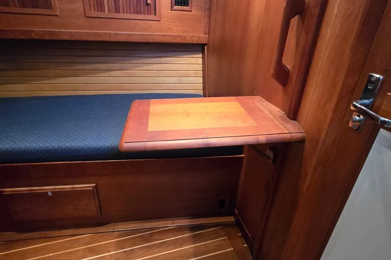 Slide: The Image of Interior of 2004 Sabre 36 yacht with wooden foldable table and blue cushioned bench. - 45