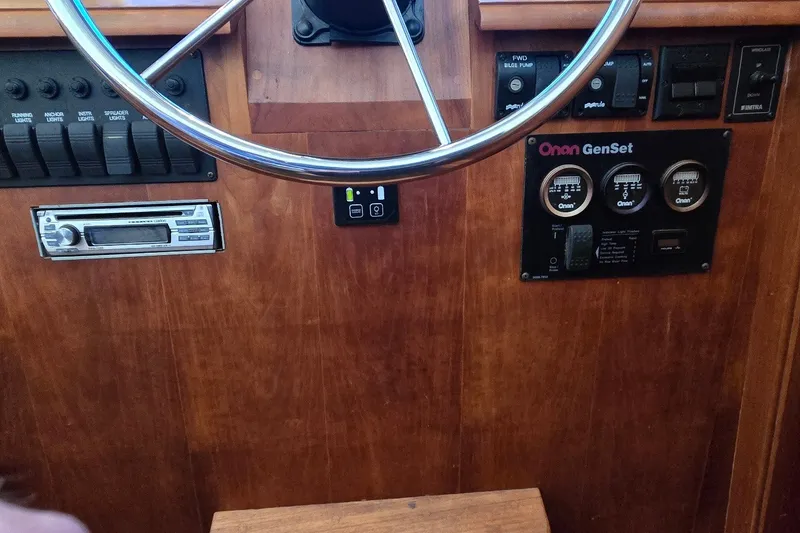 Slide: The Image of 2004 Sabre 36 boat dashboard with steering wheel, control switches, and Onan GenSet panel. - 34