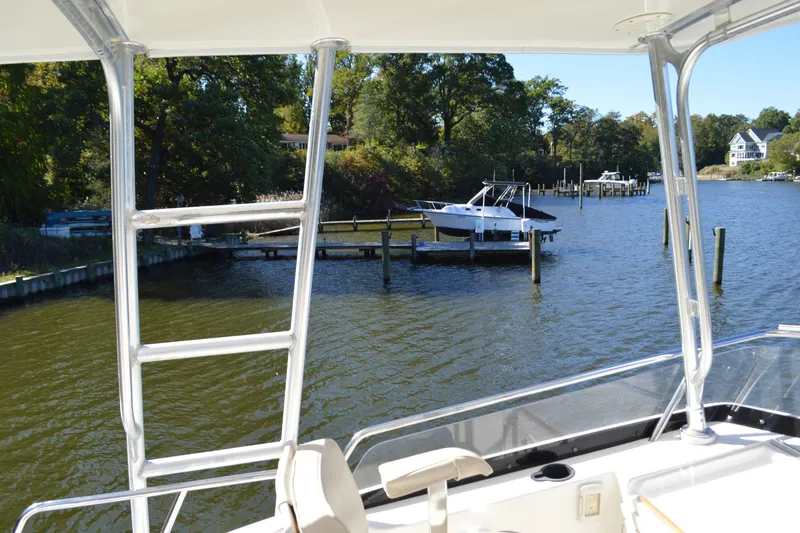 Slide: The Image of View from a 2004 Sabre 36 boat overlooking a serene dock and waterway. - 24