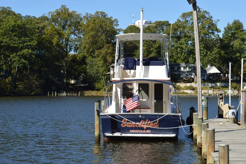 Slide: The Image of A 2004 Sabre 36 yacht docked by a scenic waterfront with trees. - 5