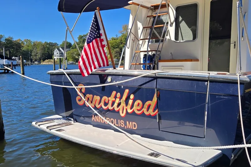 Slide: The Image of 2004 Sabre 36 boat named "Sanctified" docked in Annapolis, MD with American flag. - 14