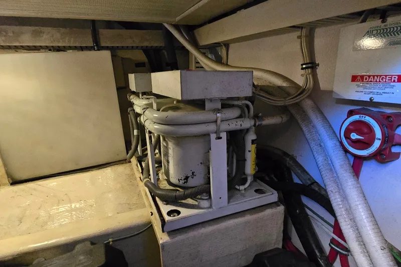 Slide: The Image of Engine room of a 2004 Sabre 36 boat, featuring mechanical components and safety controls. - 63