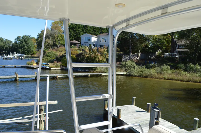 Slide: The Image of 2004 Sabre 36 yacht docked by scenic waterfront homes and lush greenery. - 23