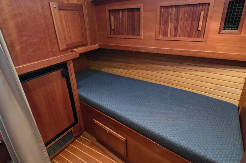 Slide: The Image of Wooden interior cabin with blue cushioned bench in a 2004 Sabre 36 boat. - 44