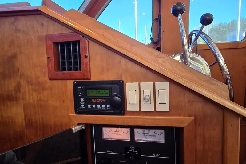 Slide: The Image of 2004 Sabre 36 boat helm with control panel, switches, and steering wheel. - 52