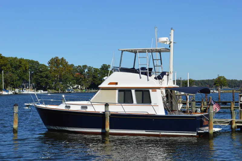Slide: The Image of 2004 Sabre 36 yacht docked on a serene lake with clear blue skies. - 2