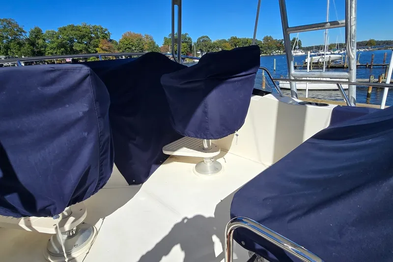 Slide: The Image of Covered seating area on a 2004 Sabre 36 boat, docked by a scenic waterfront. - 25