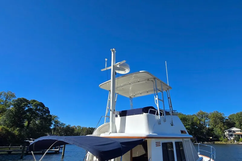 Slide: The Image of 2004 Sabre 36 boat with canopy and radar, docked under clear blue sky. - 8