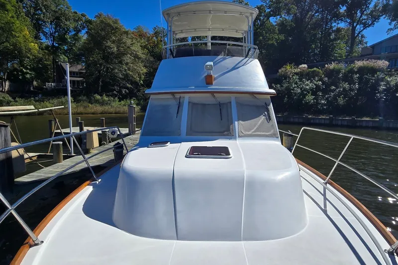 Slide: The Image of 2004 Sabre 36 yacht docked by a scenic, tree-lined waterfront. - 11