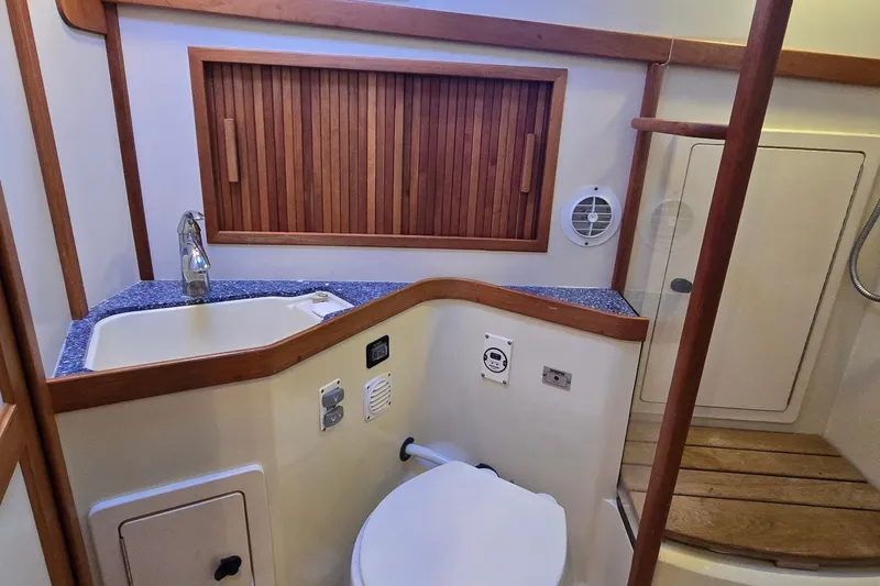 Slide: The Image of 2004 Sabre 36 yacht bathroom with sink, toilet, and wooden accents. - 46