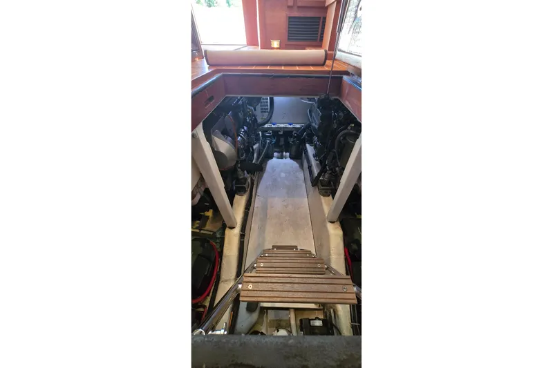 Slide: The Image of Engine room of a 2004 Sabre 36 boat, featuring a wooden ladder and visible machinery. - 54