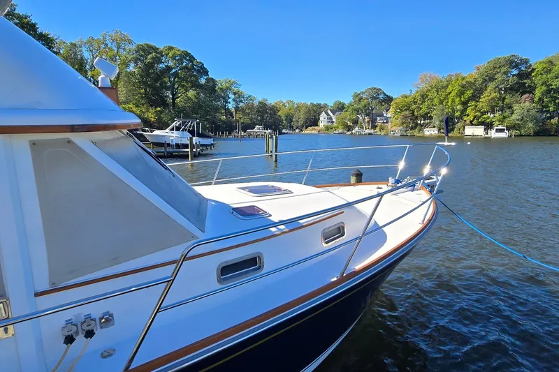 Slide: The Image of 2004 Sabre 36 yacht docked on a serene river with lush greenery. - 9