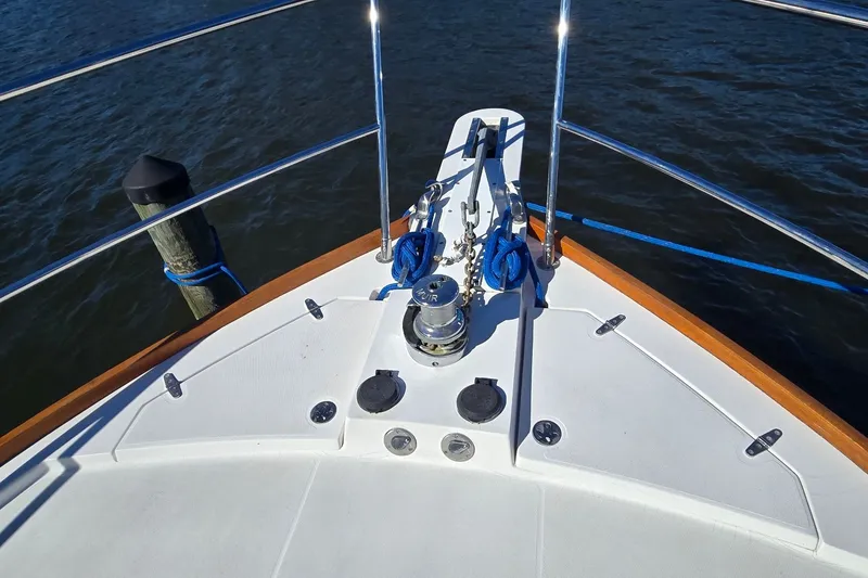 Slide: The Image of Bow of 2004 Sabre 36 yacht with anchor and railing, docked on calm water. - 12