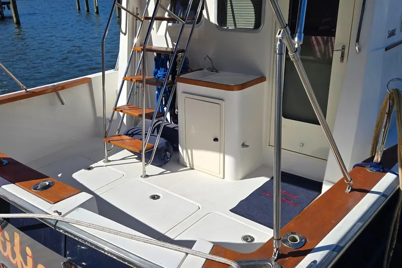 Slide: The Image of 2004 Sabre 36 boat deck with wooden steps and water view. - 16