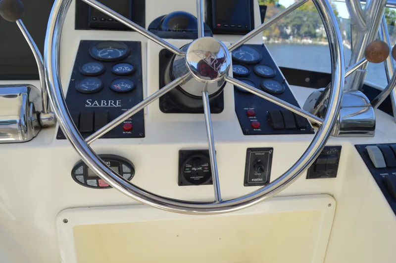Slide: The Image of Steering wheel and controls of a 2004 Sabre 36 boat cockpit. - 19