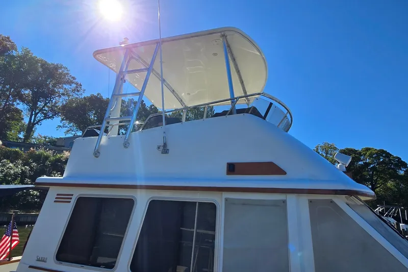Slide: The Image of 2004 Sabre 36 boat under bright sun, showcasing upper deck and sleek design. - 7