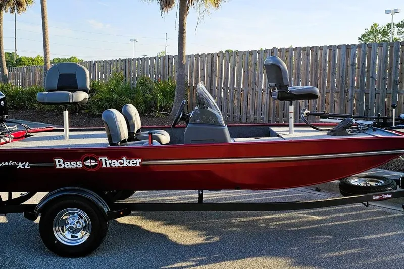 Slide: The Image of 2026 Tracker Bass Tracker Classic XL boat, red exterior, parked on trailer, outdoor setting. - 2
