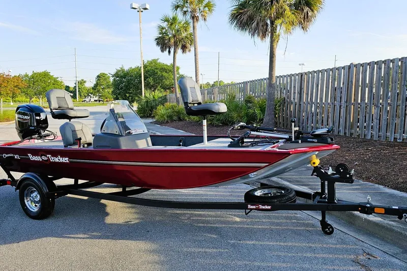 Slide: The Image of 2026 Tracker Bass Tracker Classic XL boat on trailer, parked outdoors near palm trees. - 6