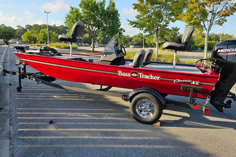 Slide: The Image of 2026 Tracker Bass Tracker Classic XL boat in vibrant red, parked on a trailer. - 7