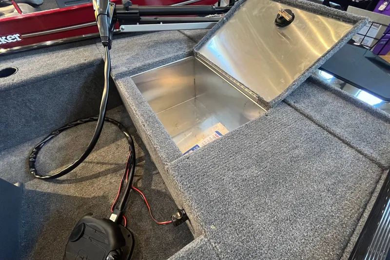Slide: The Image of Open storage compartment in 2026 Tracker Panfish 17 boat, featuring carpeted interior and wiring. - 19