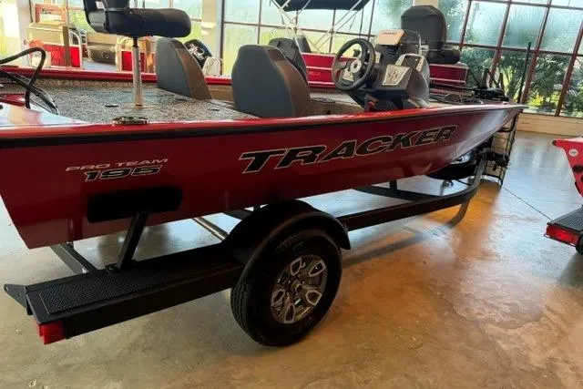 Slide: The Image of 2026 Tracker Pro Team 195 boat in showroom, featuring sleek red design and modern seating. - 2