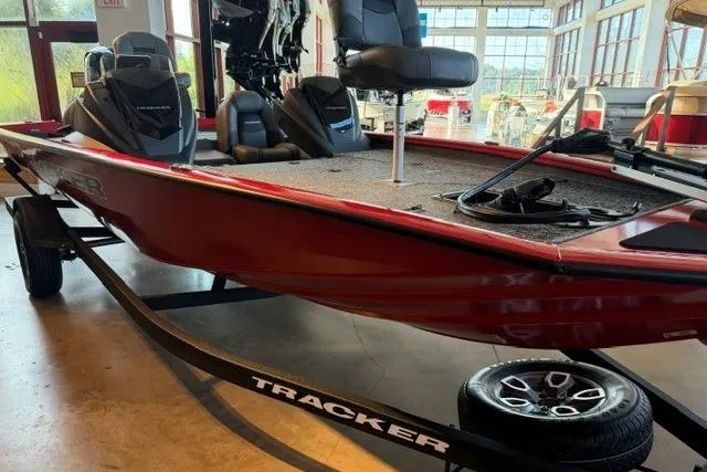 Slide: The Image of 2026 Tracker Pro Team 195 boat in showroom, featuring red hull and fishing seats. - 3
