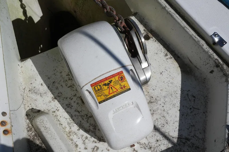 Slide: The Image of Anchor windlass on 1999 Beneteau 381 sailboat deck, showing warning label and chain. - 13