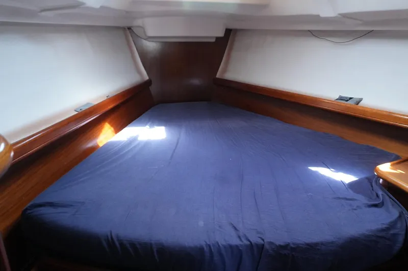 Slide: The Image of Cozy cabin interior of 1999 Beneteau 381 sailboat with blue bedding. - 25