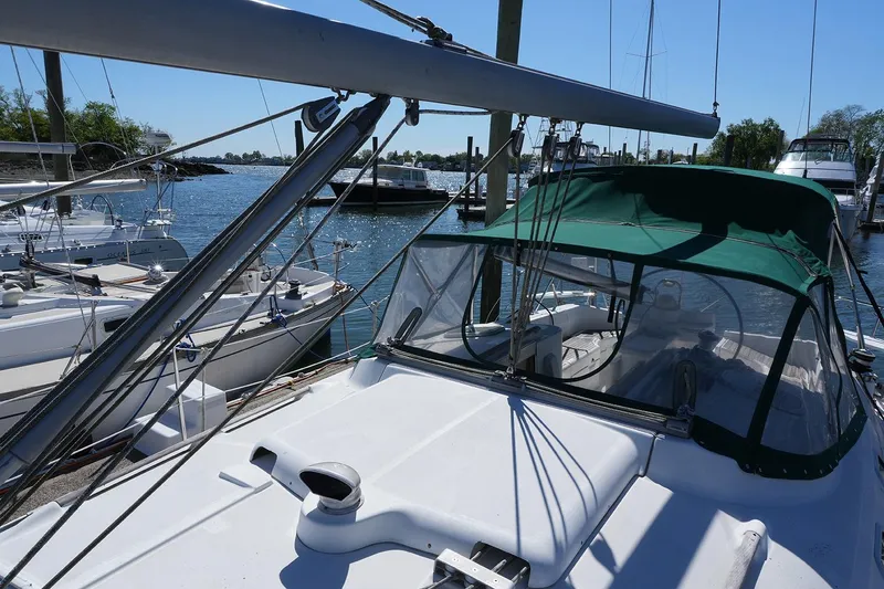 Slide: The Image of Sailboat Beneteau 381, 1999 model, docked at marina with green canopy. - 4