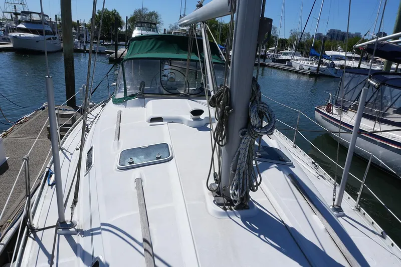 Slide: The Image of 1999 Beneteau 381 sailboat docked at marina, showcasing deck and rigging. - 5